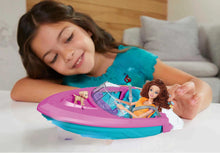 Young girl playing with a toy boat and dolls on a bed